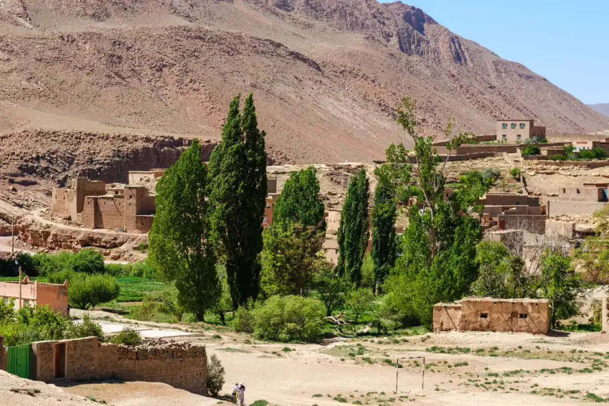 Village de terre et cyprès au pied d’une montagne, dans l’Atlas marocain