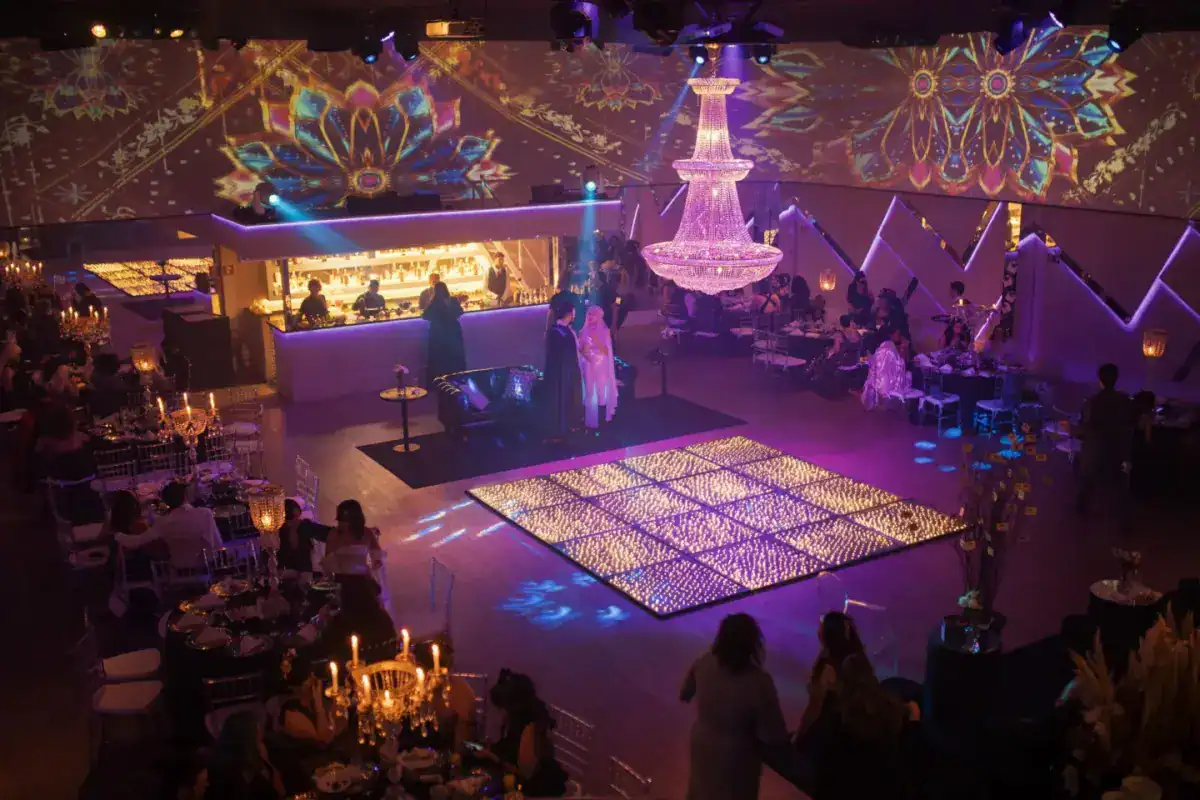 Piste de danse lumineuse et scène d’une salle de réception, éclairages colorés