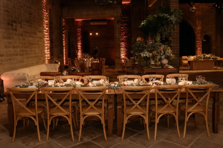 Table de mariage aux chandelles dans une salle aux murs de brique éclairés de lumière chaude