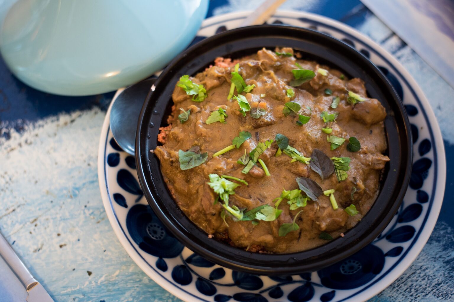 Tajine marocain garni d'herbes fraîches, servi à table