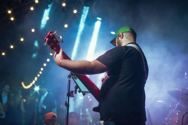Musiciens sur une petite scène éclairée lors d'une soirée privée en extérieur à Marrakech, vue de dos