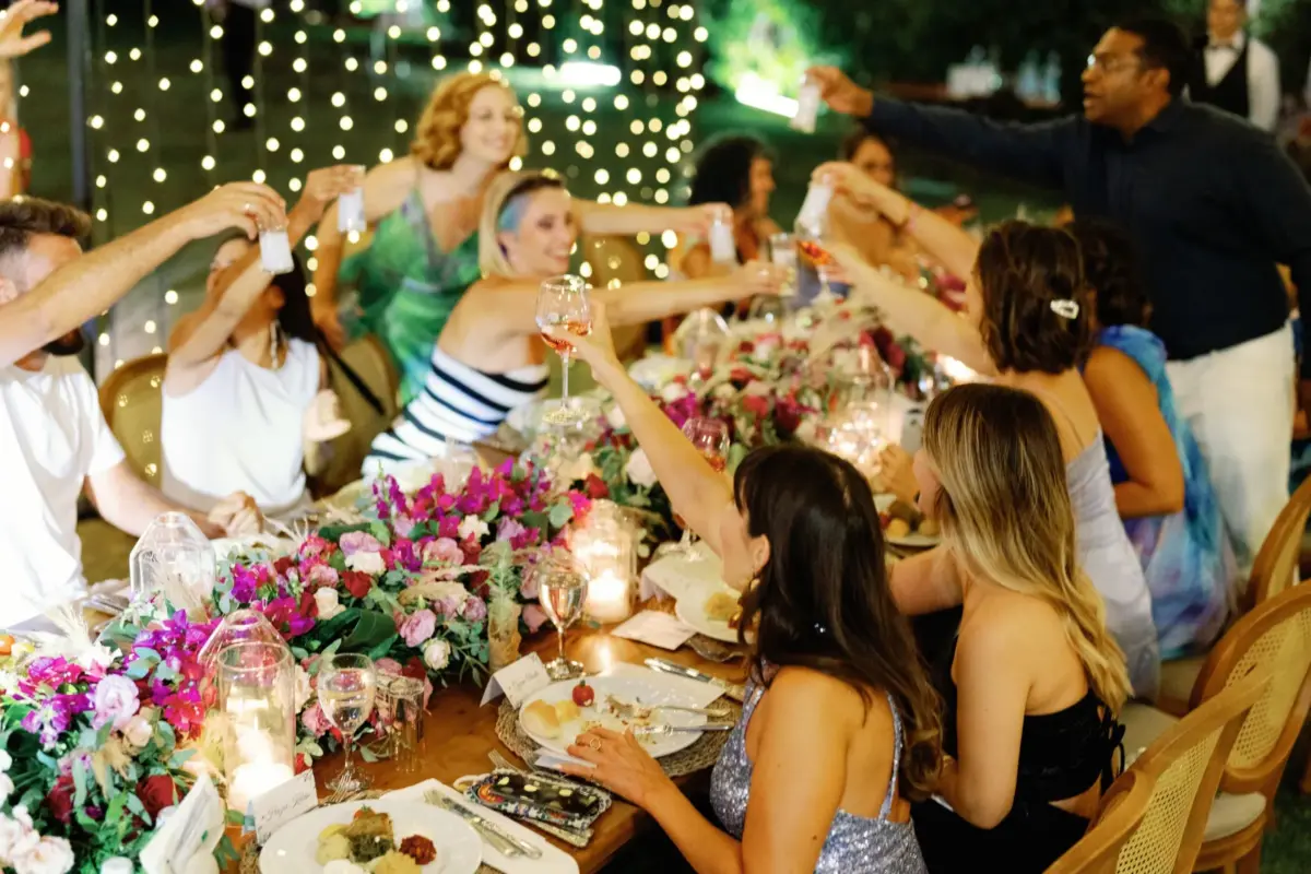 Friends raising a toast at a flower-decked birthday dinner table