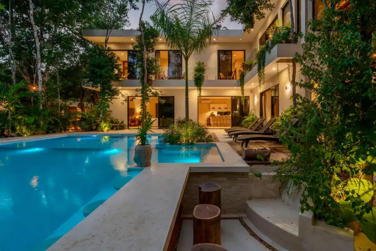 Jardin et piscine d’une villa privatisée, éclairés pour une soirée