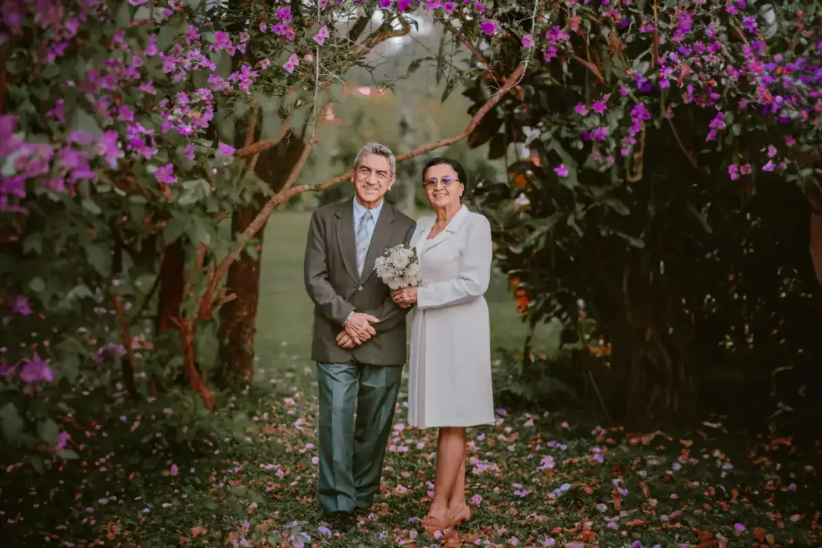 Couple enlacé dans un jardin fleuri, lors d’une célébration d’anniversaire de mariage