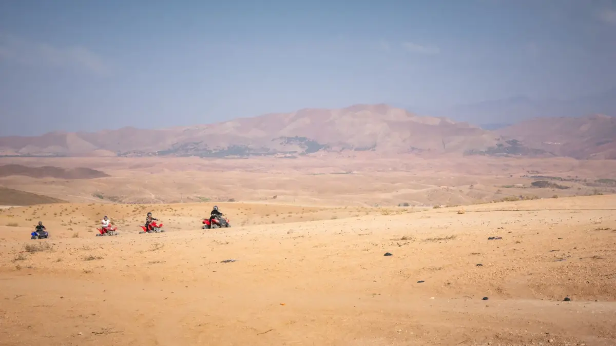 Group quad ride across the Agafay desert with the Atlas foothills behind