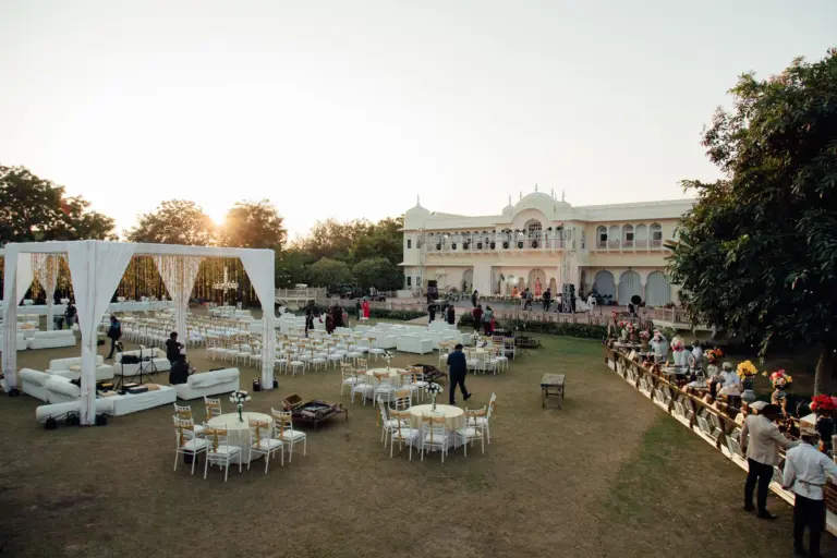 Réception en plein air dans le jardin d'un domaine, tentes blanches et tables dressées