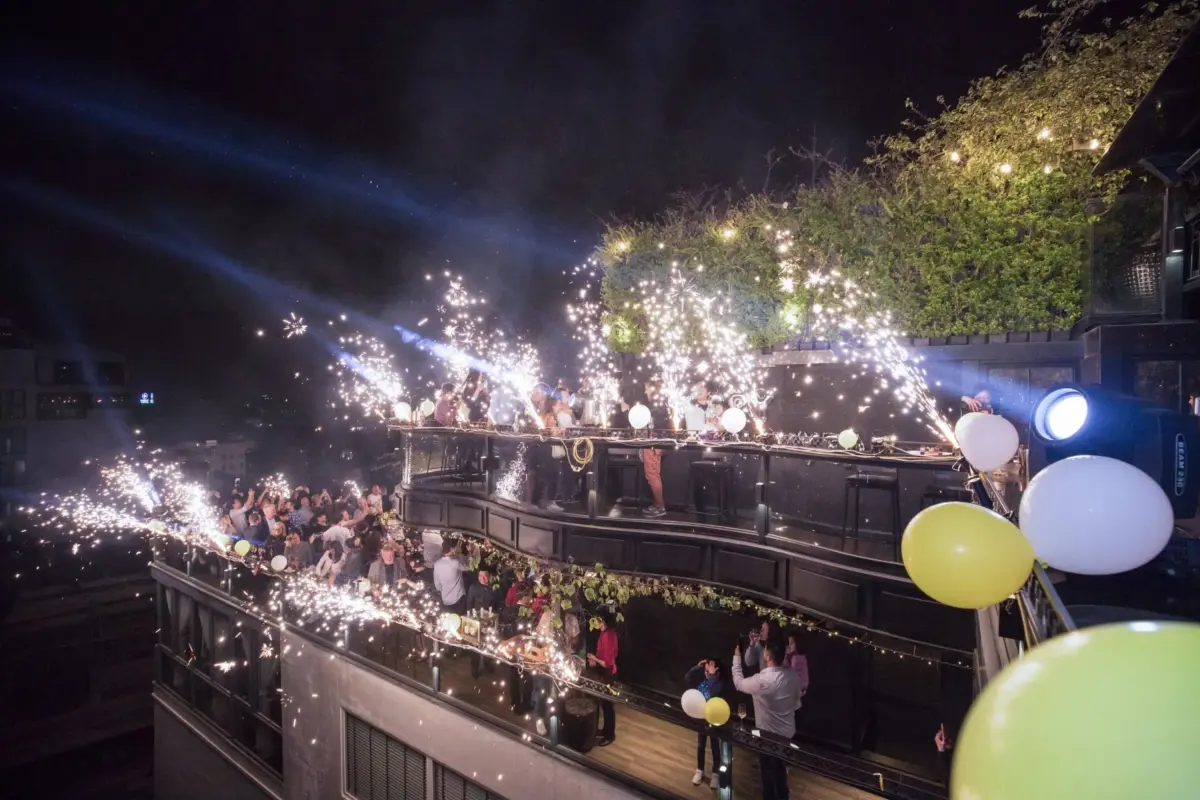 Soirée de réveillon sur un rooftop : fontaines d'étincelles et ballons