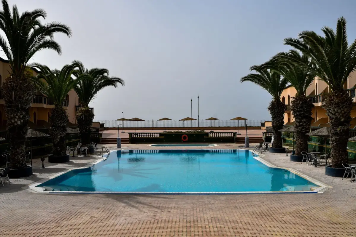 Piscine bordée de palmiers dans un hôtel au Maroc