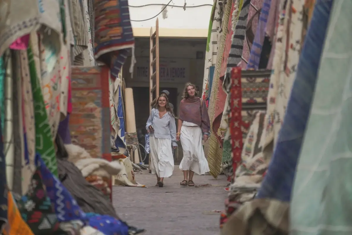 Deux participantes marchent dans le souk aux tapis de la médina de Marrakech