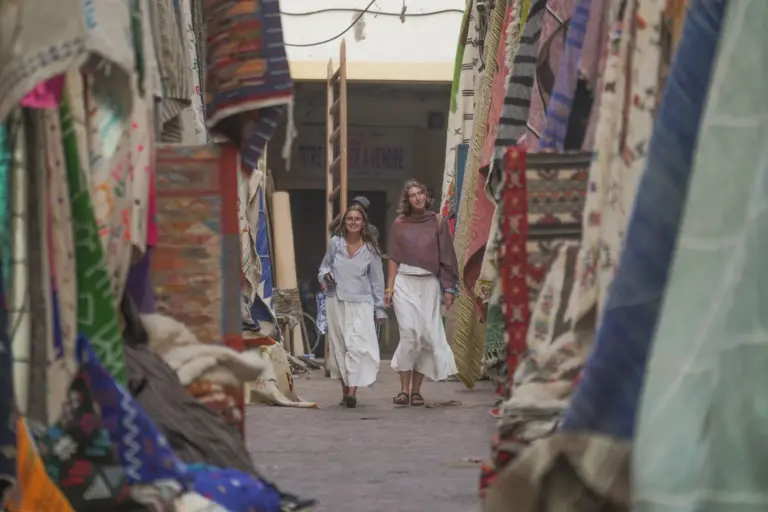 Deux participantes marchent dans le souk aux tapis de la médina de Marrakech