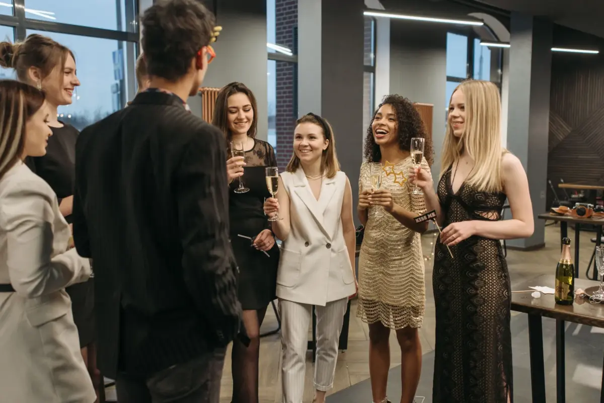 Collègues debout, une coupe de champagne à la main, pendant un cocktail d'entreprise