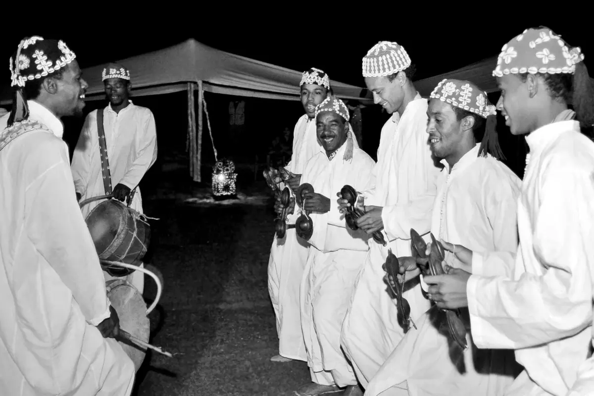 Musiciens gnaoua en tenue traditionnelle animant une soirée sous tentes à Marrakech