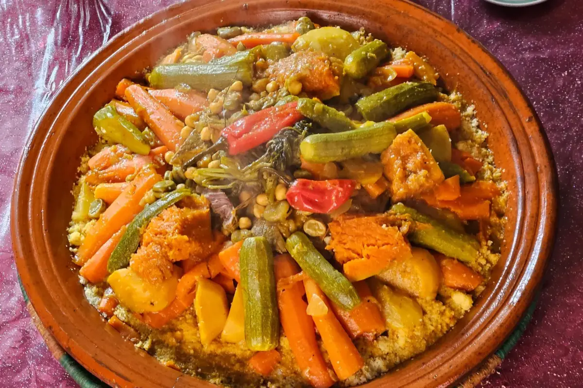 Couscous aux légumes de saison servi dans un plat en terre cuite au Maroc