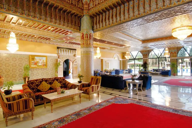 Hall d'hôtel de style marocain avec plafonds sculptés, lustres et salons