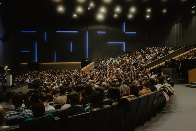 Participants d'une séance plénière assis dans un auditorium face à l'orateur