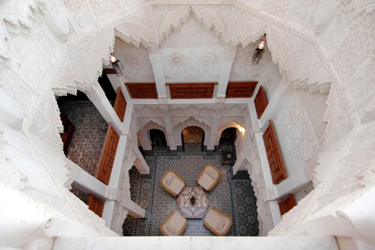 Équipe de dix personnes en réunion autour d'une table dans le patio d'un riad de Marrakech