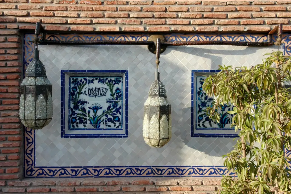 Lanternes et carreaux de zellige sur un mur de brique à Marrakech