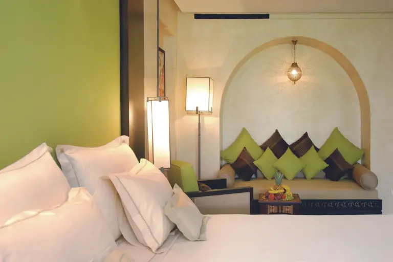 Chambre d'hôtel à Marrakech avec banquette marocaine et coussins, pour un week-end d'anniversaire