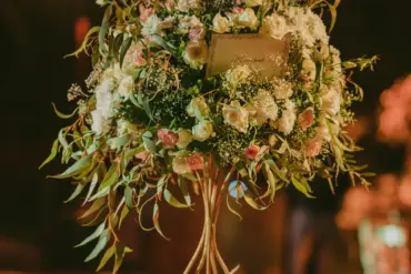 Composition florale haute sur une table de réception de mariage en soirée à Marrakech