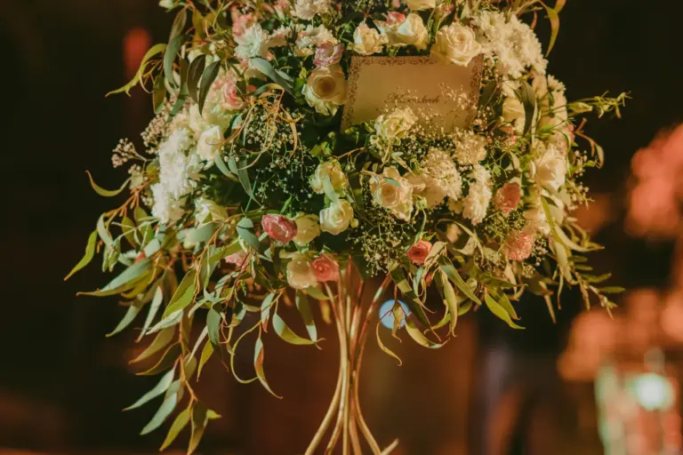 Composition florale haute sur une table de réception de mariage en soirée à Marrakech