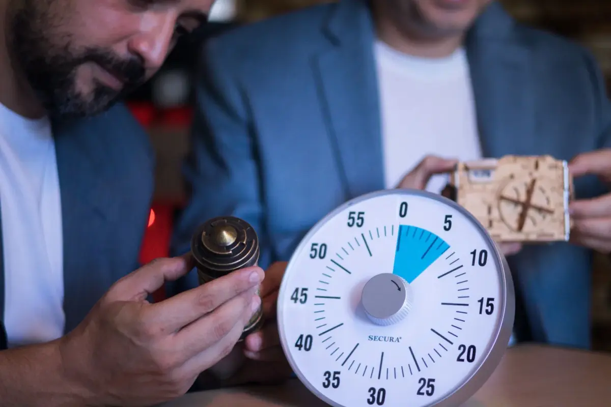 Deux collègues ouvrent un cadenas à énigme face au chrono d'un escape game