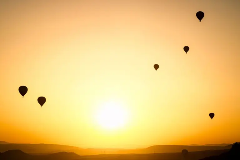 Montgolfières en silhouette dans le ciel au lever du soleil