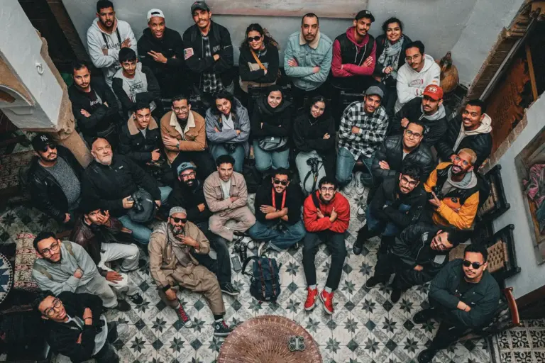 Grand groupe réuni dans la cour carrelée d’une maison traditionnelle au Maroc