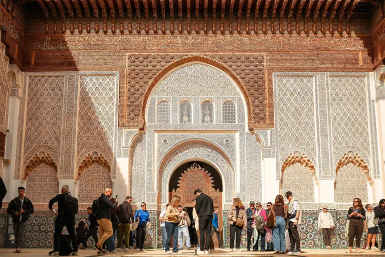 Groupe de visiteurs de plusieurs pays dans la cour de la médersa Ben Youssef à Marrakech