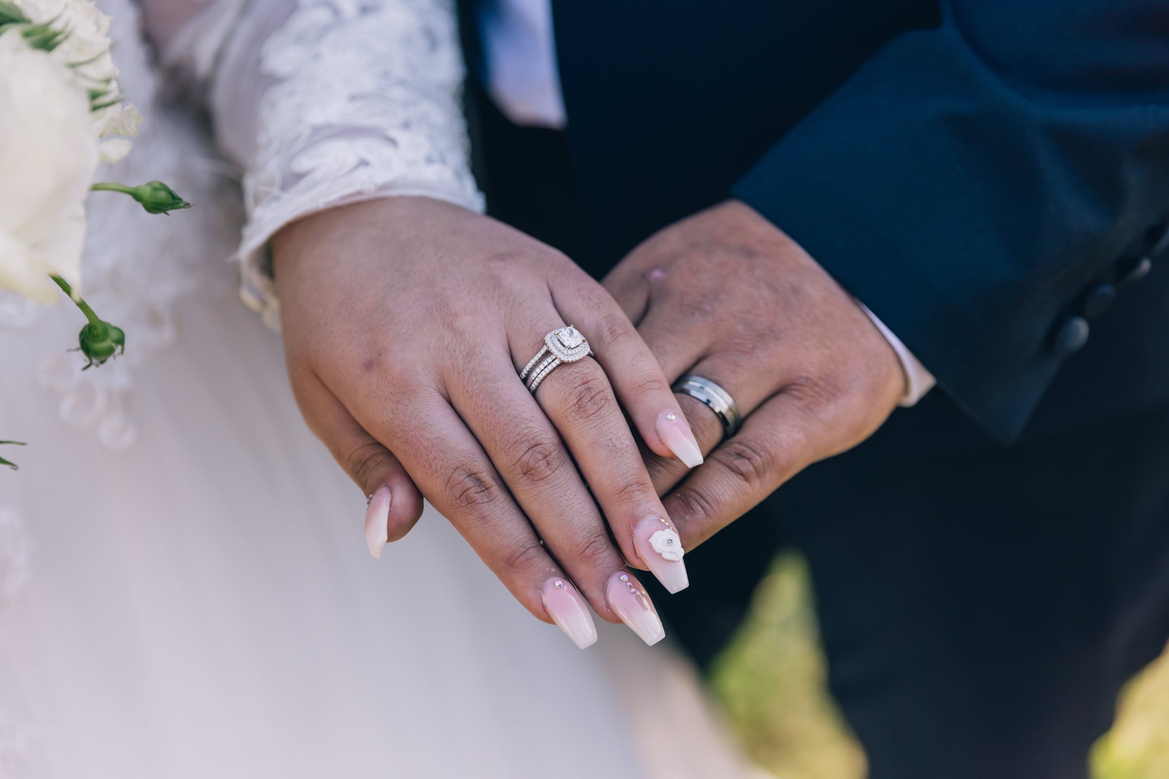 Mains d'un couple de mariés montrant leurs alliances