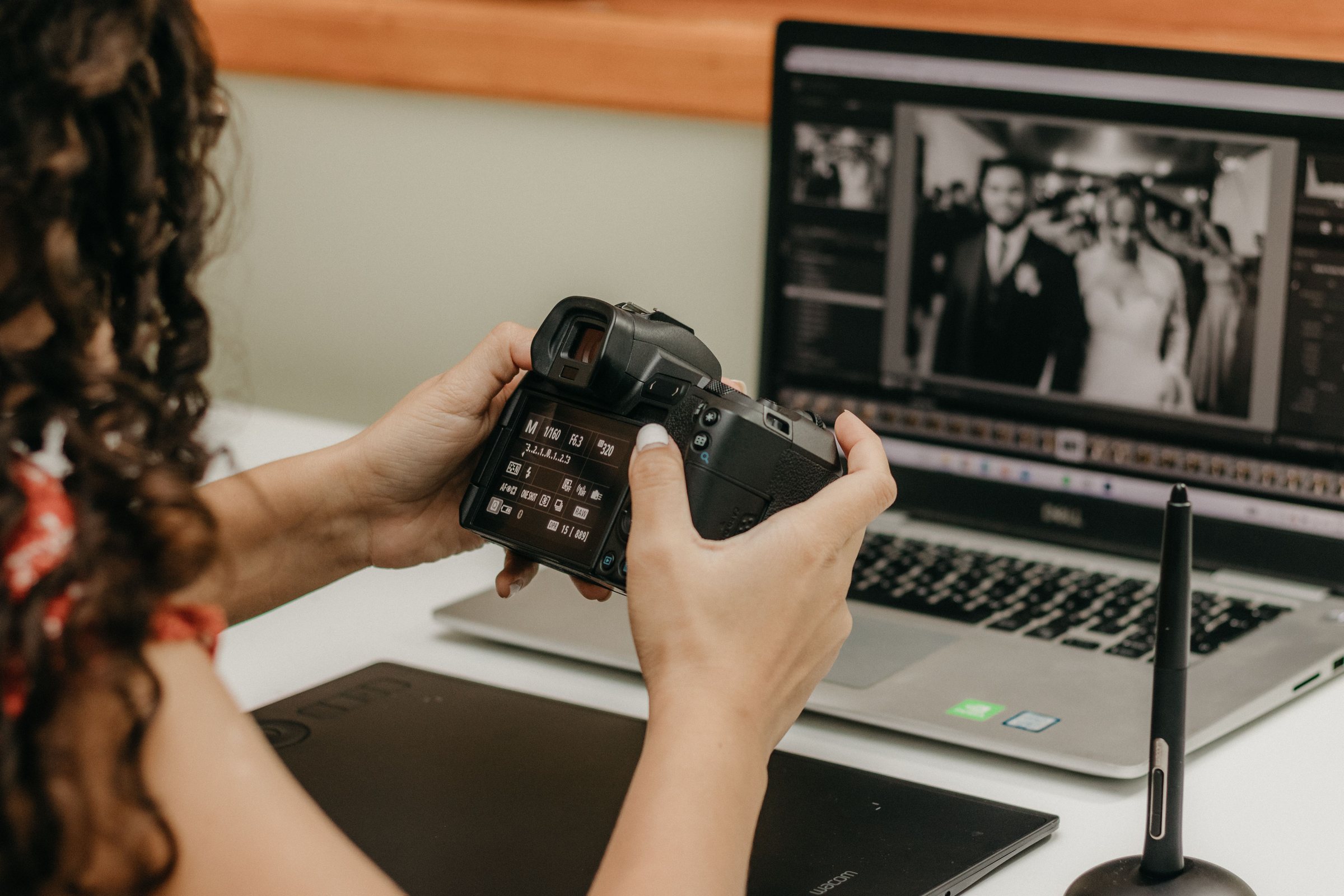 Photographe vérifiant son appareil devant des photos de mariage à l'écran