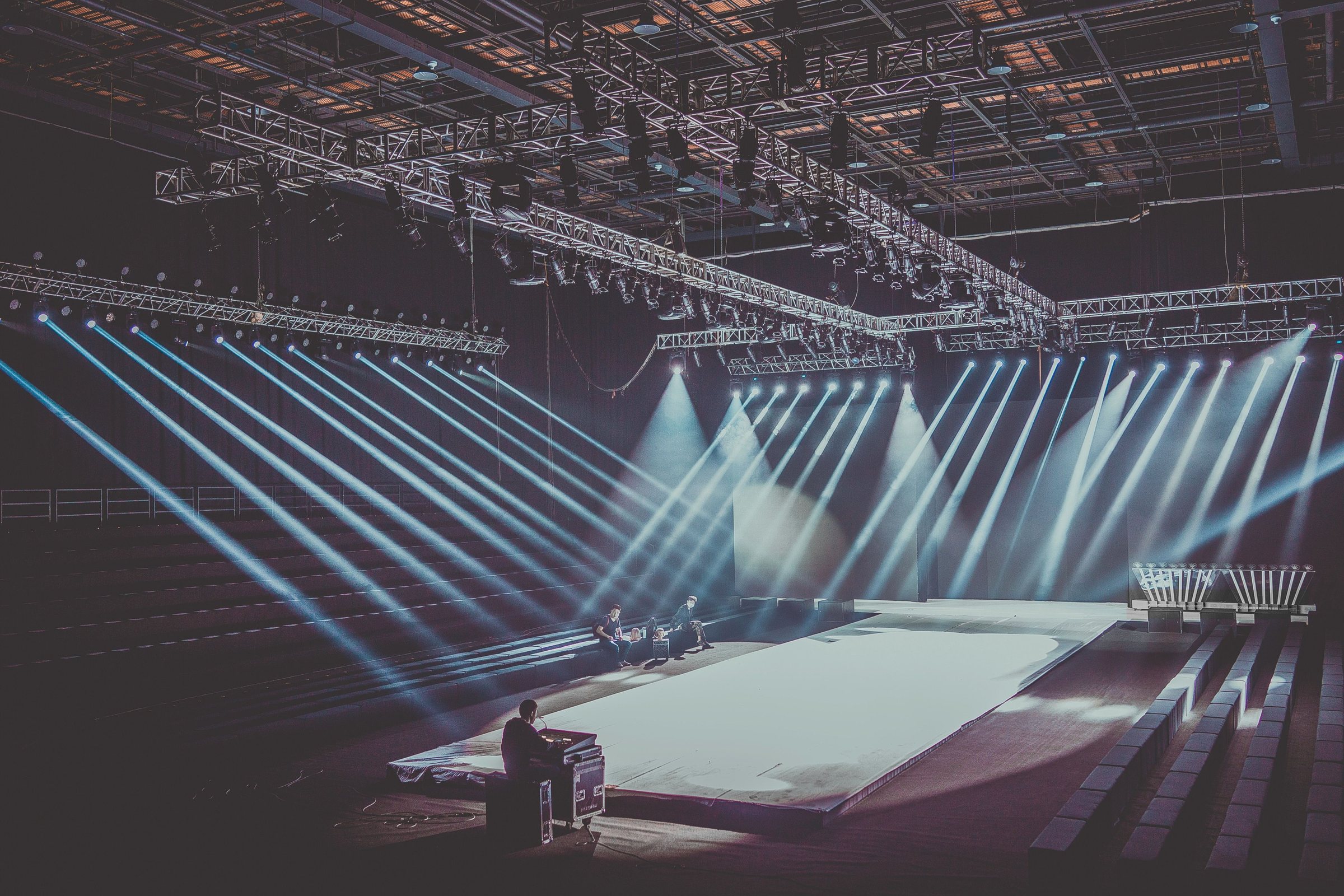 Salle d'événement avec faisceaux lumineux et scène en préparation