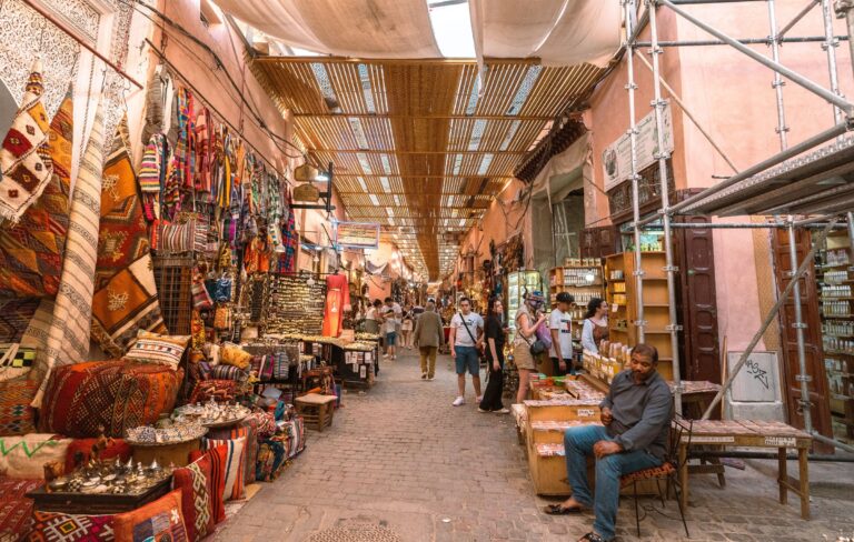 Ruelle couverte du souk de Marrakech, tapis, coussins et étals