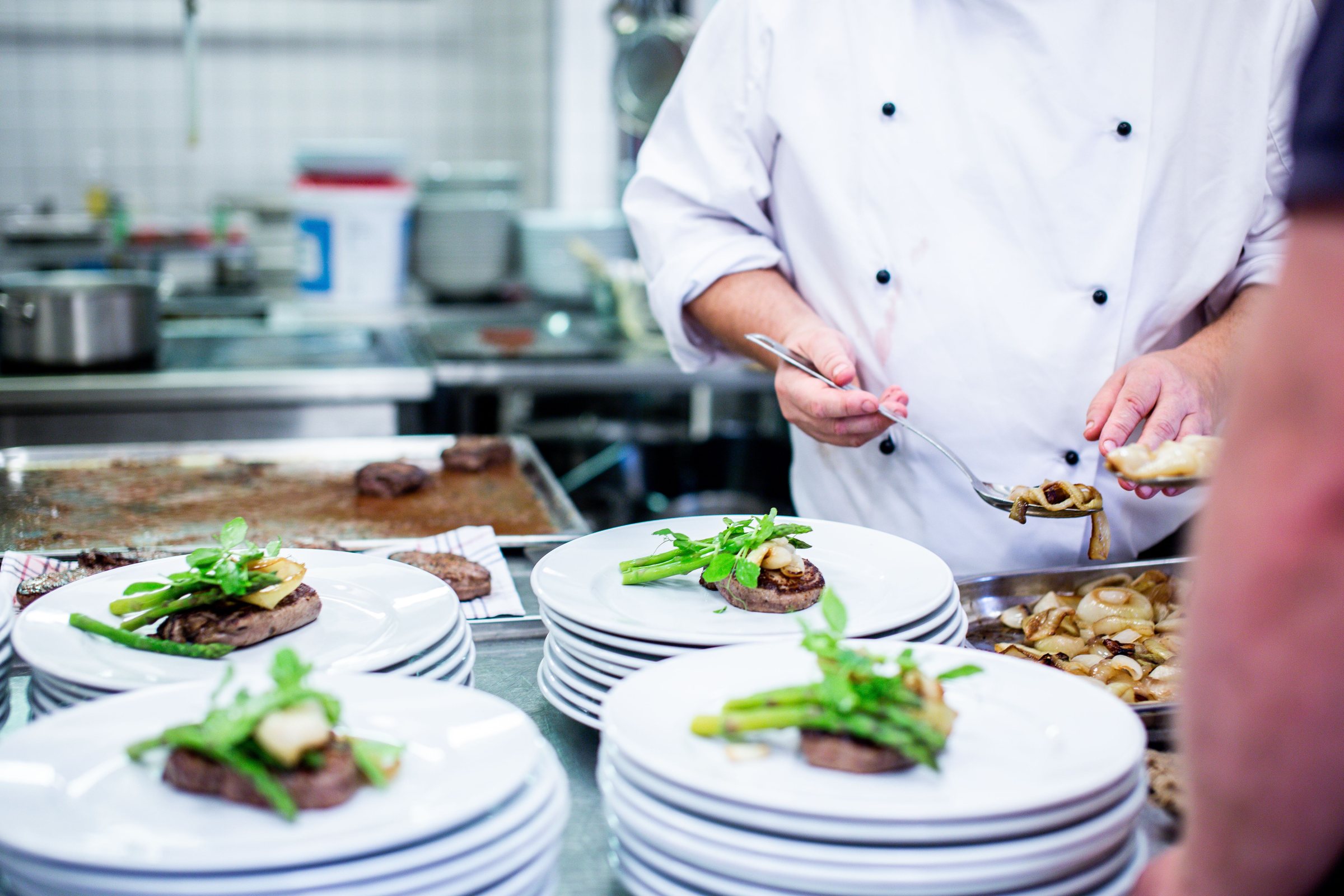 Chef dressant des assiettes en cuisine professionnelle