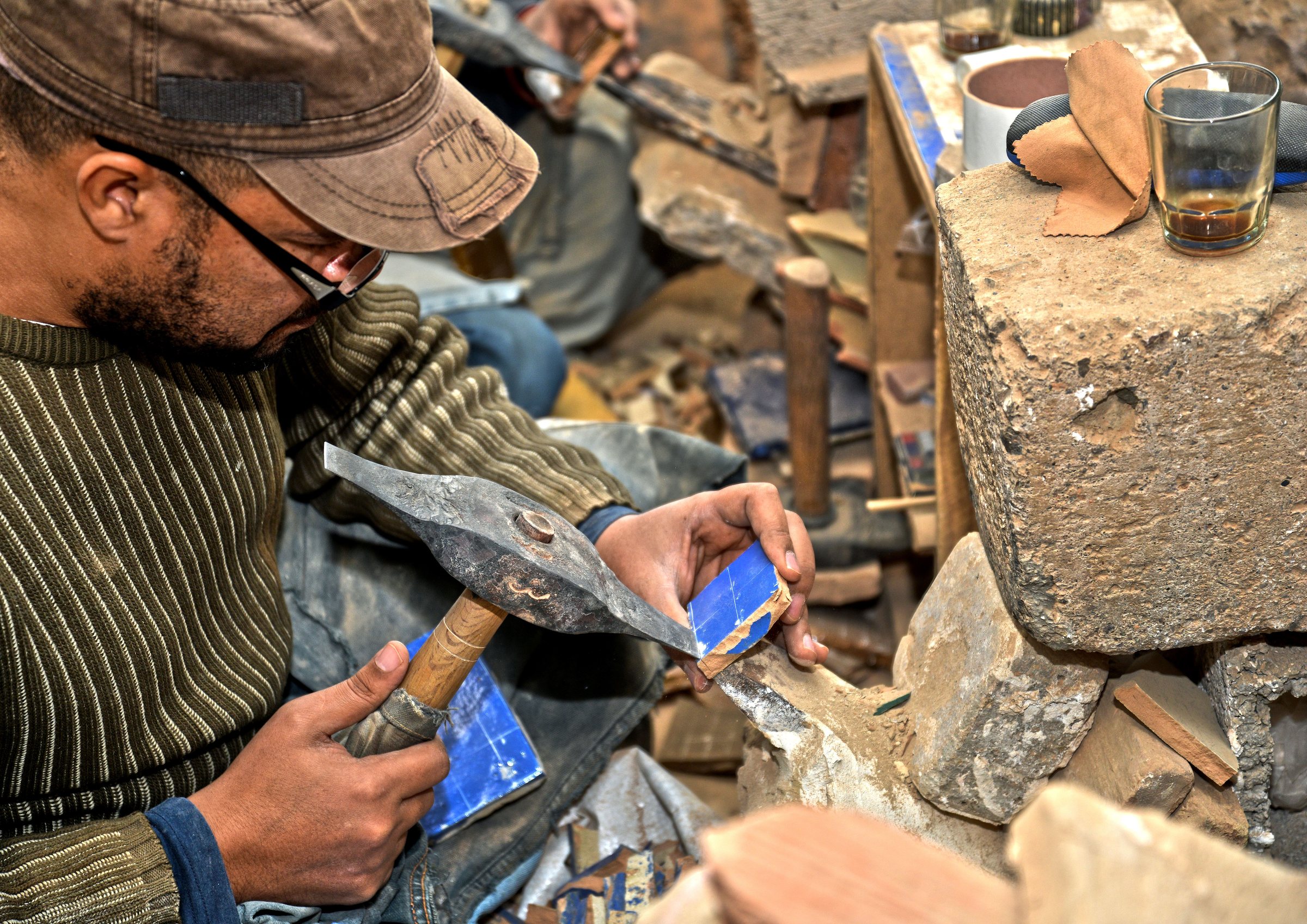 Artisan taillant des carreaux de zellige à la main