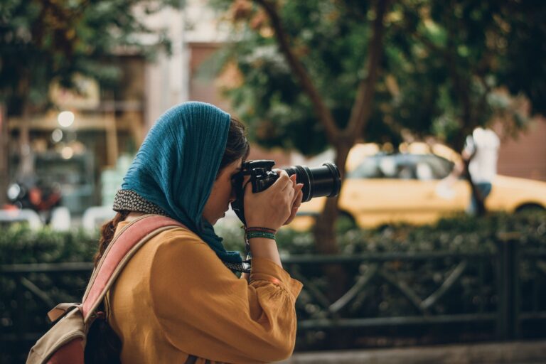 Femme en foulard photographiant une rue de Marrakech