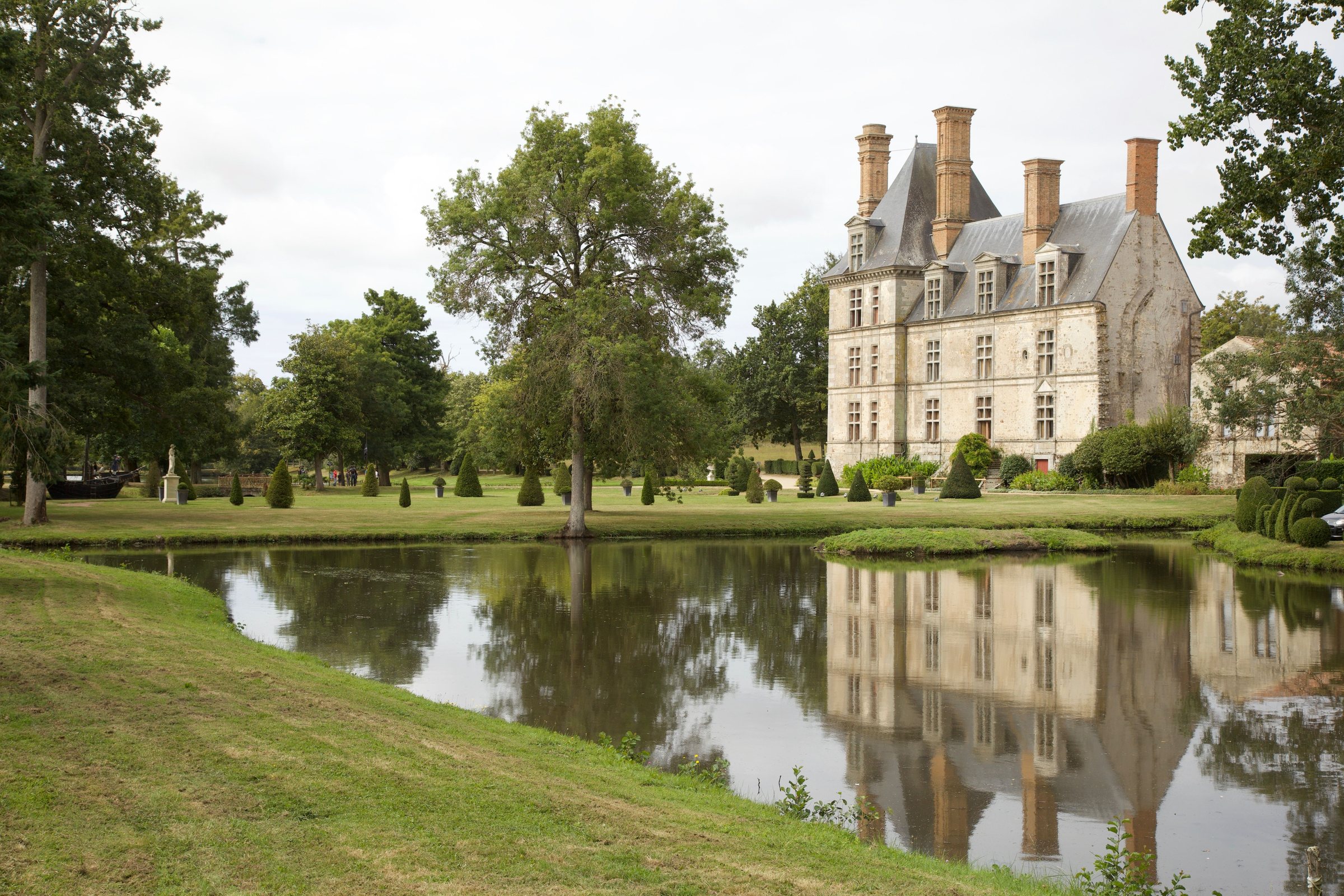 Château entouré d'un parc, reflété dans un étang