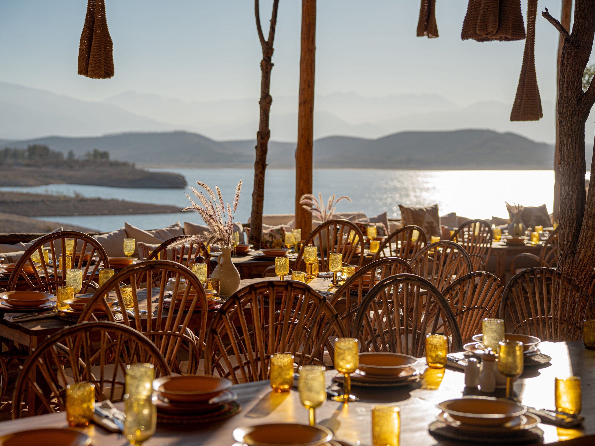 Tables de dîner dressées face au lac de Lalla Takerkoust au coucher du soleil