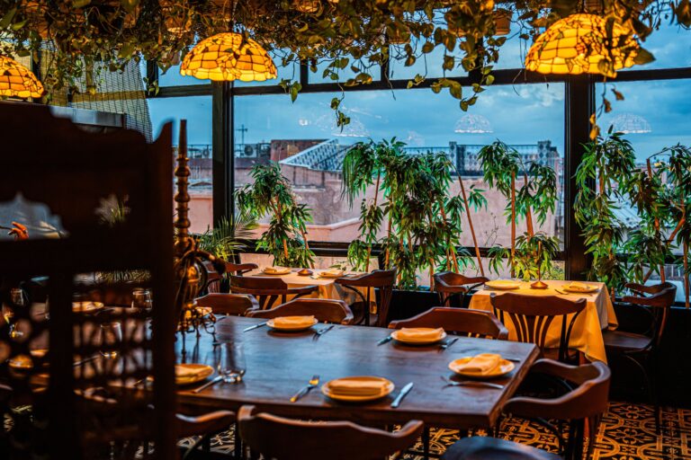 Salle de restaurant aux lampes Tiffany avec vue sur les toits