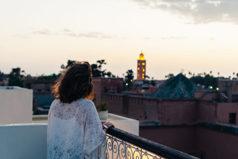 Femme sur un balcon face au minaret de la Koutoubia au crépuscule