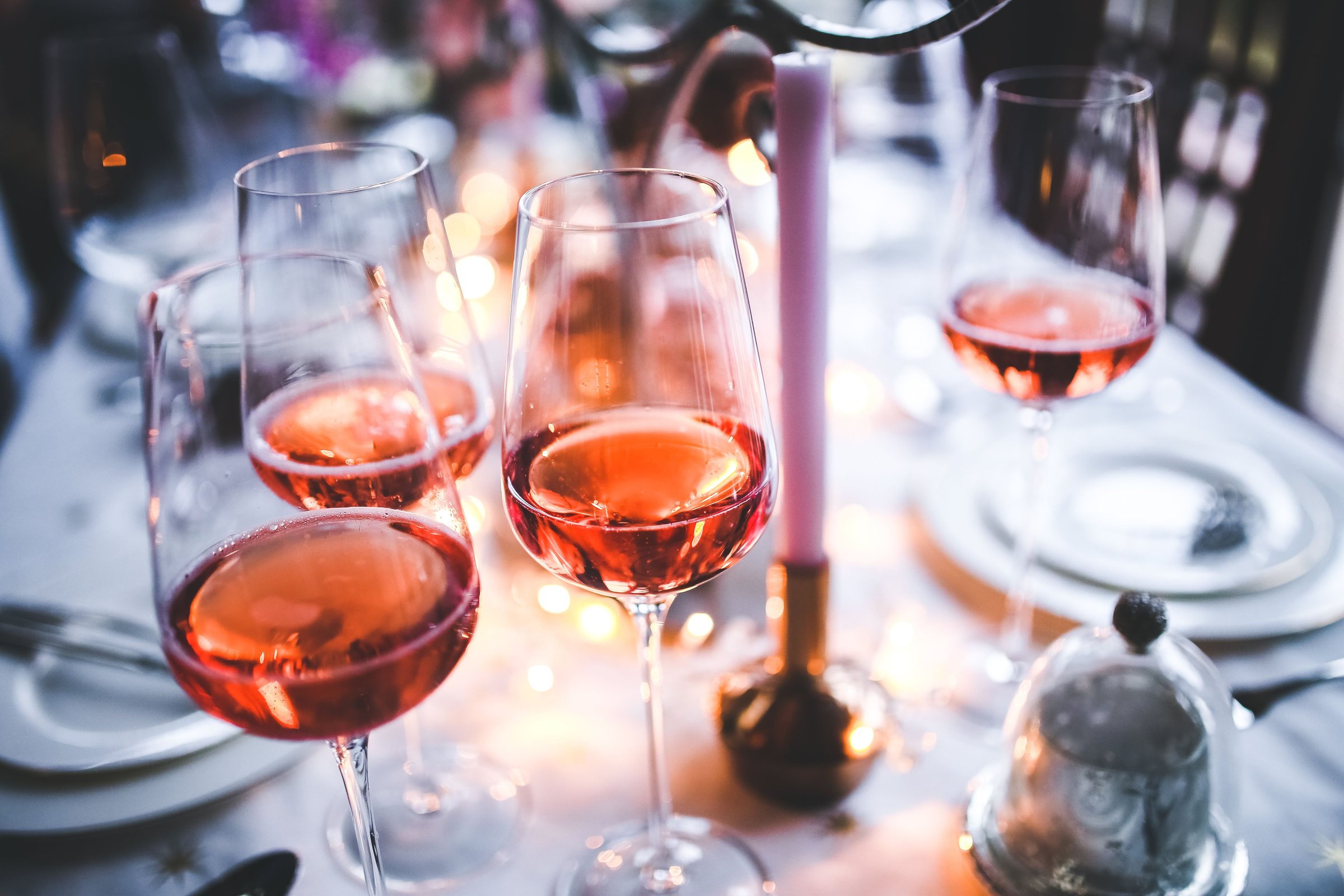 Verres de vin rosé sur une table de dîner aux chandelles