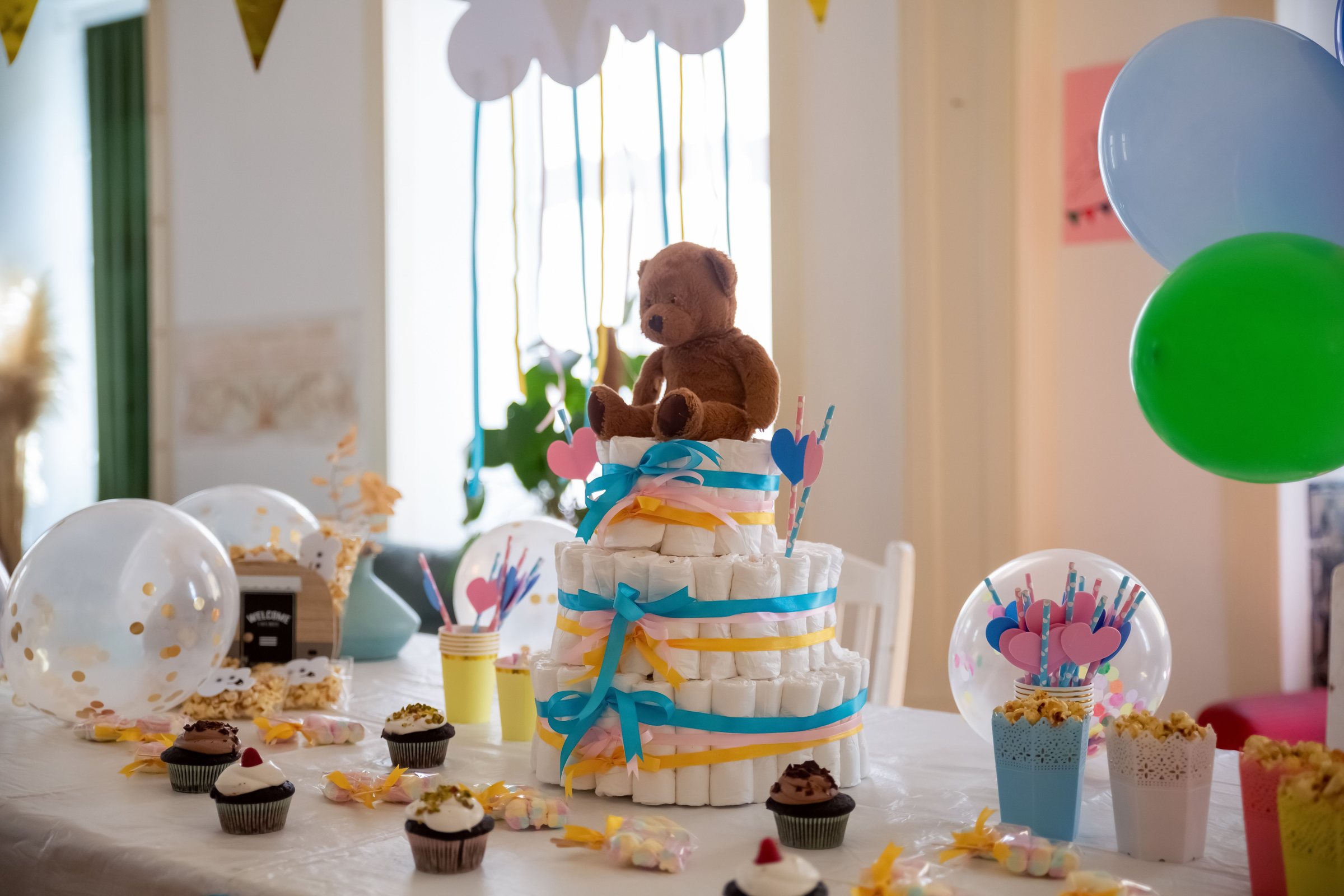 Table de baby shower avec gâteau de couches, ours en peluche et ballons